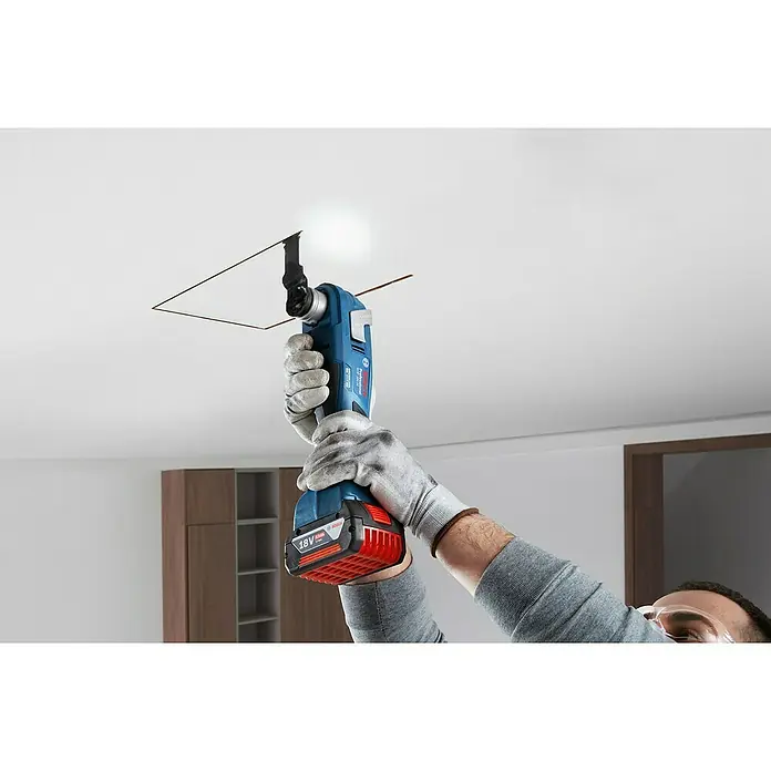 Bosch Professional AMPShare 18V Akku-Multifunktionswerkzeug GOP 18V-34 - 18 V, Ohne Akku - Handwerker schneidet mit einem Bosch Multifunktionswerkzeug ein Loch in eine Decke.
