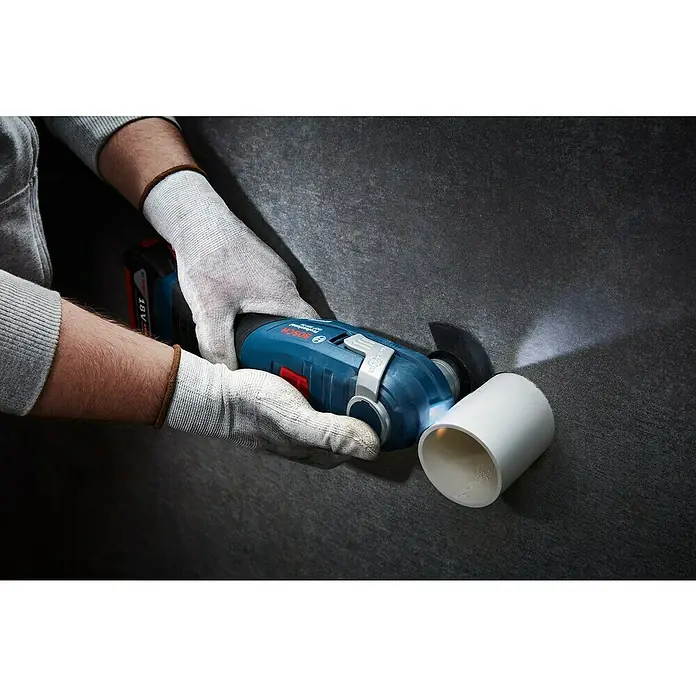 Bosch Professional AMPShare 18V Akku-Multifunktionswerkzeug GOP 18V-34 - 18 V, Ohne Akku - Ein Bosch GOP 18V-28 Akku-Multifunktionswerkzeug mit LED-Licht schneidet ein weißes Kunststoffrohr.