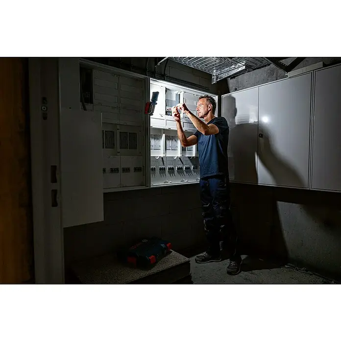 Bosch Professional AMPShare 18V LED-Akkustrahler GLI 18V-800 - 18 V, Ohne Akku, Lichtstrom: 800 lm - Ein Handwerker, der mit einer Bosch-Leuchte an einem Sicherungskasten arbeitet, beleuchtet die Elektrik professionell.