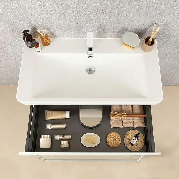 Lanzet K2 Waschtischunterschrank - 117,9 x 45,3 x 48,9 cm, Grafit - Ein Waschbecken mit einer offenen Schublade, die eine Vielzahl von Badartikeln wie Lotionen und Handtücher enthält.