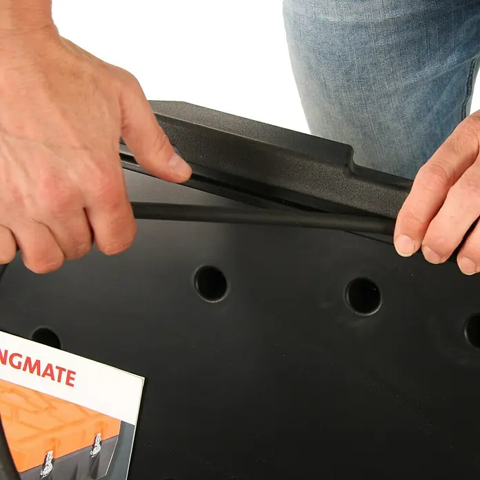 Hepco & Becker Aufbewahrungs- & Transportbox Strongmate 2002 - L x B x H: 590 x 880 x 320 mm, 83 l, High Density Polyethylen (HDPE) - Detailansicht einer schwarzen Werkzeugkiste mit Dichtung und Broschüre. Die Hände sind im Bild, die die Dichtung anbringen.