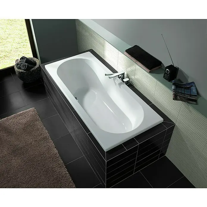 Villeroy & Boch O.novo Badewanne - 180 x 80 cm, Sanitäracryl, Weiß - Weisse Badewanne mit schwarzer Umrandung in einem modern gefliesten Badezimmer. Handtuch und Radio liegen auf dem Sims.
