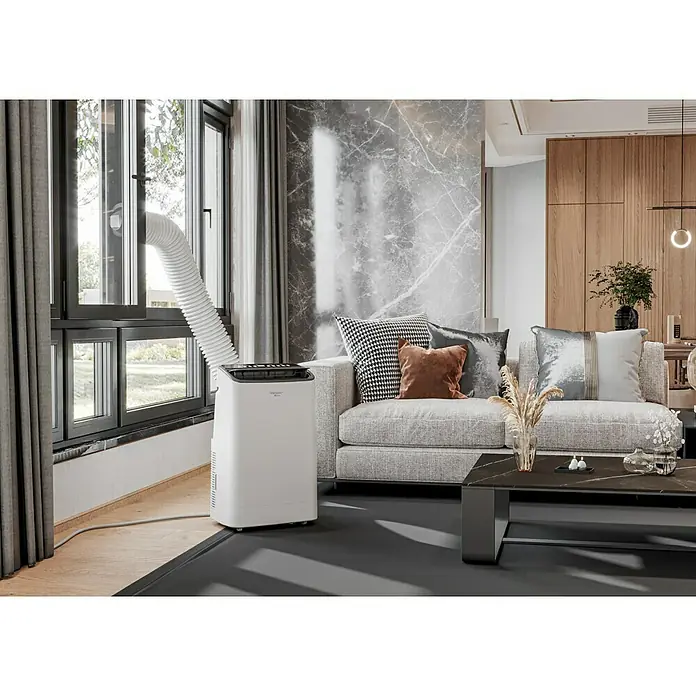 Voltomat Aire acondicionado portátil Yakutsk - 5.200 W, Tamaño de la estancia: 52 m², Blanco - Una sala de estar moderna con un aire acondicionado portátil junto a la ventana, que garantiza una temperatura confortable.