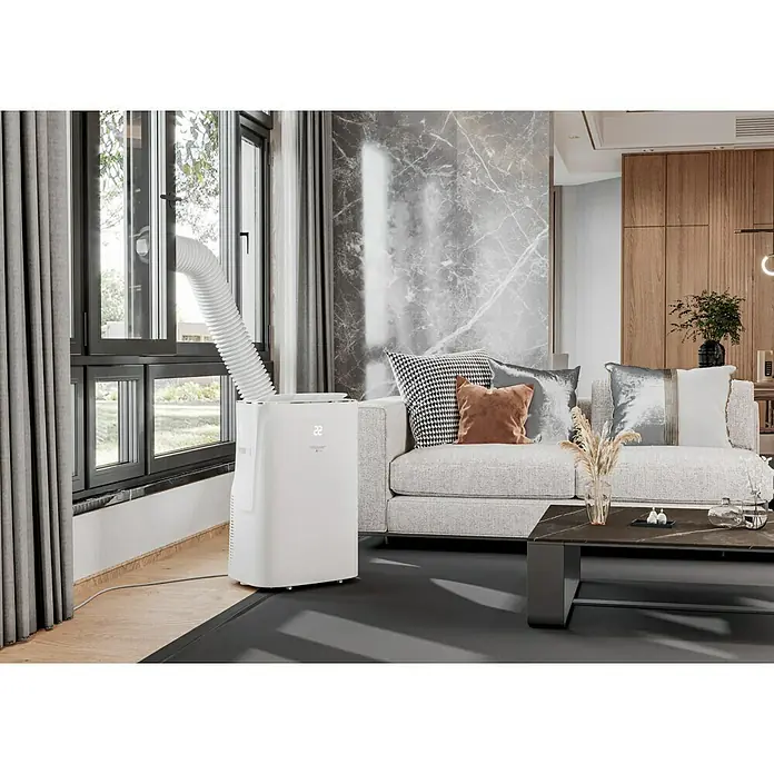 Voltomat Aire acondicionado portátil Hefesto - 3.500 W, Tamaño de la estancia: 35 m², Blanco - Un aire acondicionado portátil con manguera de escape está colocado en el salón. Es blanco y tiene una pantalla.