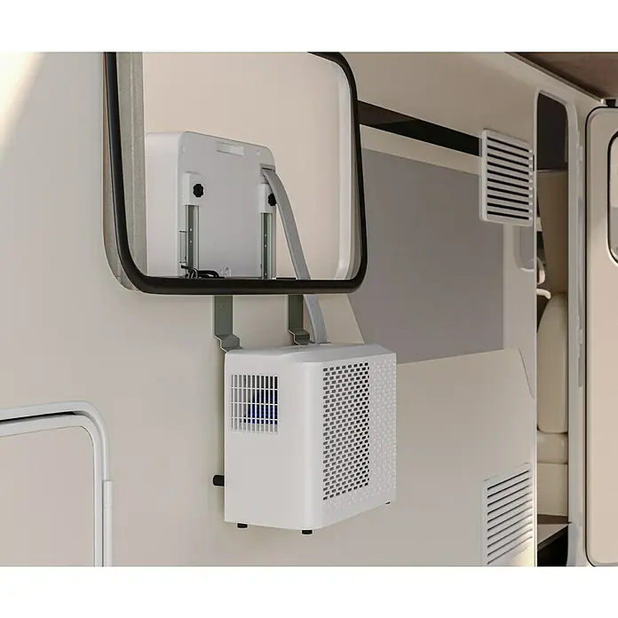 Voltomat Klimasplitgerät Camping - Kühlleistung: 500 W - 1.500 W, Raumgröße: 10 m² - 15 m² - Tragbarer Klimaanlage am Fenster eines Wohnmobils. Der Klimaanlage ist weiß und mit einem Gitter versehen.