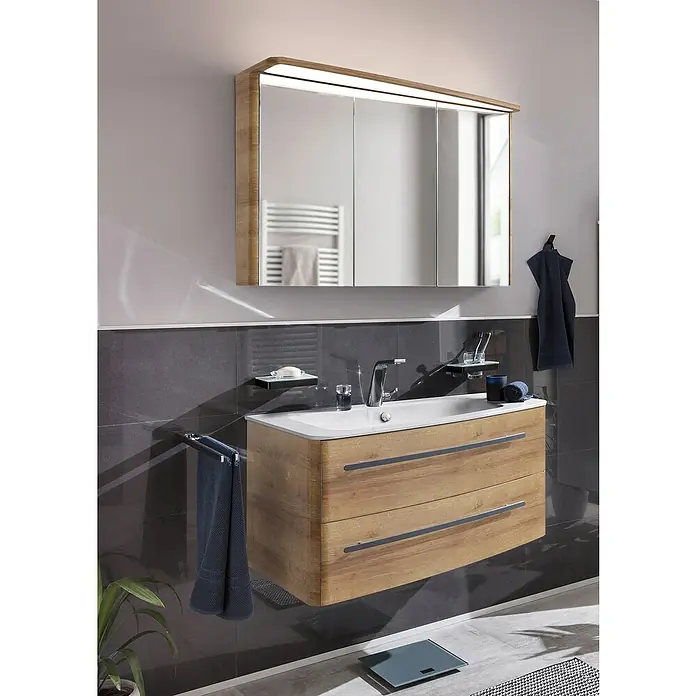 Lanzet Classico Badmöbel-Set CL10RWBA - 99,2 cm, Berg Eiche, Farbe Griff: Anthrazit, Rechts - Ein modernes Badezimmer mit einem Waschtischunterschrank aus Holz und einem Spiegelschrank mit integrierter Beleuchtung.