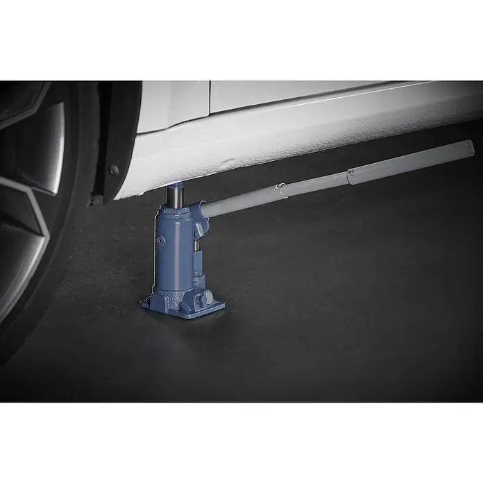 Cartrend Hydraulischer Flaschenwagenheber - 2.000 kg - Eine Nahaufnahme eines blauen Wagenhebers, der ein weißes Auto anhebt, wobei der Fokus auf dem Werkzeug und seiner Funktion liegt.