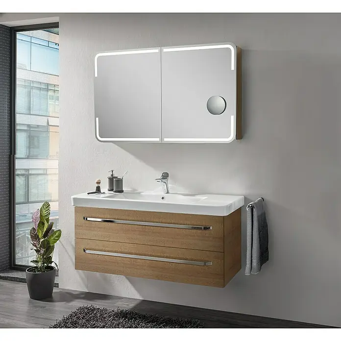 Lanzet K2 Badmöbel-Set K222B2 - 117,9 cm, Berg Eiche - Ein moderner Badezimmerschrank mit Holzstruktur und integriertem Waschbecken, darüber ein beleuchteter Spiegelschrank. Elegantes Design für jedes Bad.