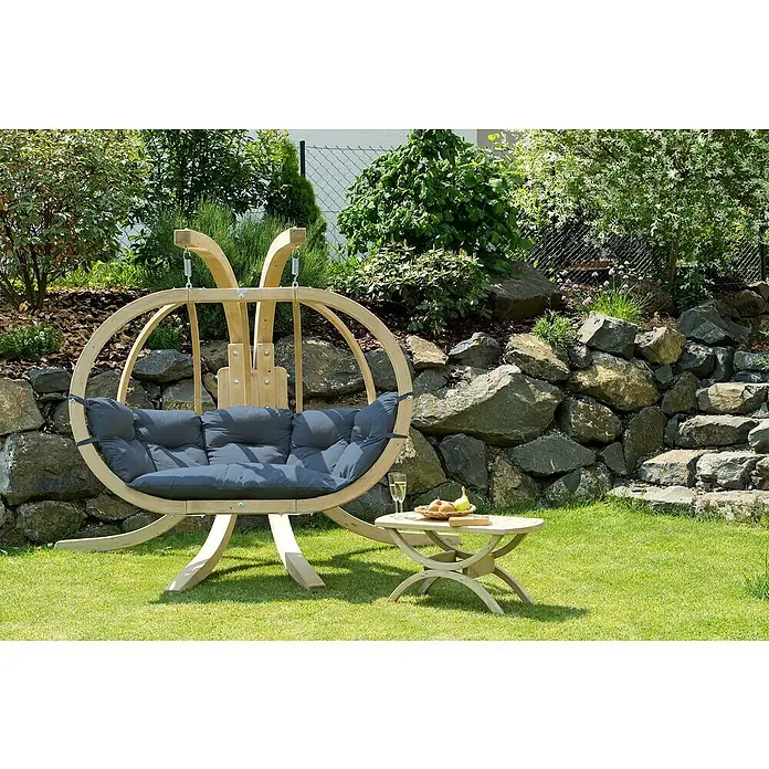 Amazonas Hängesesselgestell Globo Royal Stand - L x B x H: 238 x 149 x 181 cm, Holz - Eine stilvolle, hölzerne Gartenschaukel mit grauen Kissen und Beistelltisch, ideal für entspannte Stunden im Freien.
