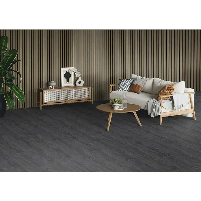 b!design Wandpaneel Wall Prime Akustikline - Eiche Rustikal, 2.440 x 535 mm - Ein gemütliches Wohnzimmer mit dunklem Holzboden, hellem Sofa und Holztisch. Ein modernes und einladendes Ambiente mit stilvoller Dekoration.
