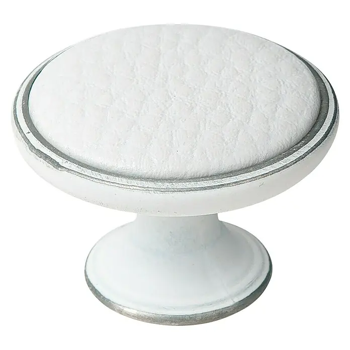 Nesu Pomo para muebles Piel - Ø x Al: 37 x 26 mm, Blanco - Primer plano de un tirador de mueble blanco con incrustación de cuero y detalles plateados sobre fondo negro.