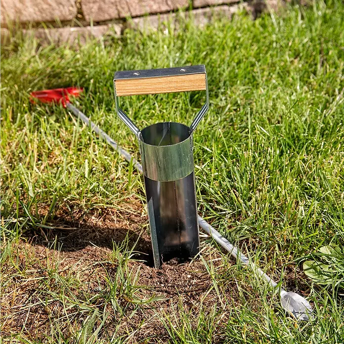 Windhager Zubehör-Set für Wühlmausfallen - 2 -tlg., Metall, Verzinkt - Nahaufnahme eines Gartenwerkzeugs, das in den Boden gesteckt wurde, um das Einpflanzen von Setzlingen zu erleichtern. Hilfreich, um präzise Löcher zu schaffen.
