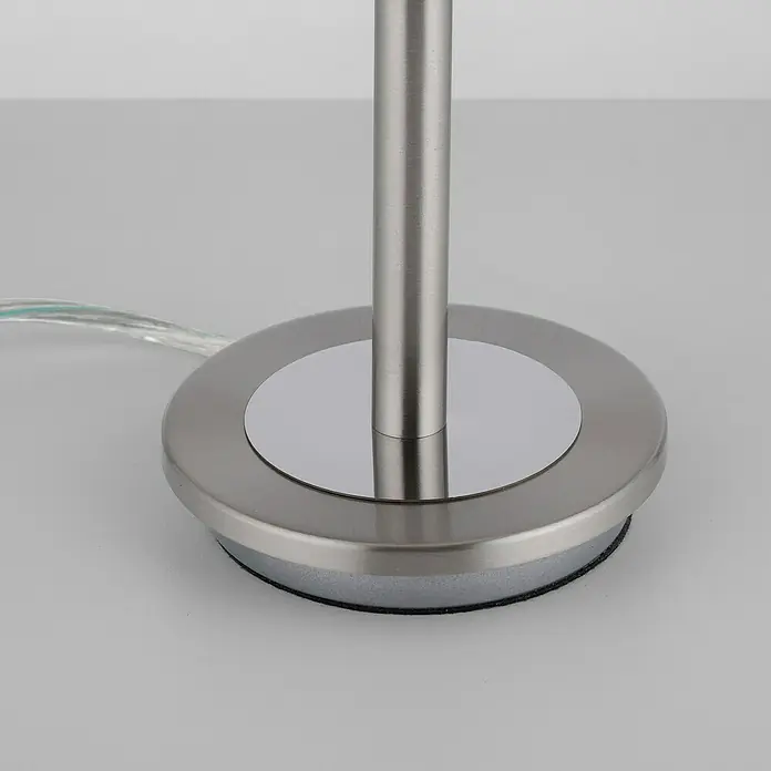 Paul Neuhaus Tischleuchte Enova - 3 W, L x B x H: 20 x 20 x 28 cm, Stahl, Weiß - Nahaufnahme des modernen Lampenfußes aus gebürstetem Metall mit einem runden Sockel und einem transparenten Stromkabel.