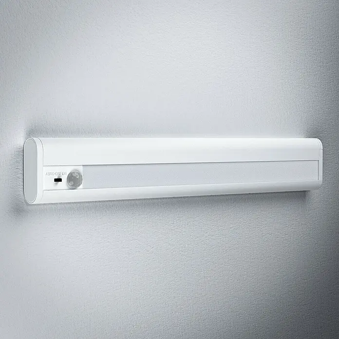 Ledvance LED-Unterbauleuchte Mobile - 2,9 W, Bewegungssensor, L x B x H: 31,4 x 4,8 x 1,8 cm, Weiß - Eine weiße LED-Leuchte mit Bewegungssensor ist an einer Wand befestigt und bietet automatische Beleuchtung.