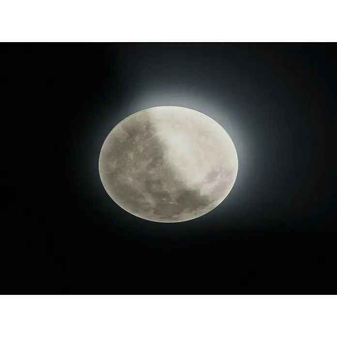 Trio Leuchten LED-Deckenleuchte rund Lunar - 22 W, Ø x H: 40 x 10 cm, Grau - Nahaufnahme einer dekorativen Mondlampe, die ein sanftes, atmosphärisches Licht in einem dunklen Raum verbreitet.