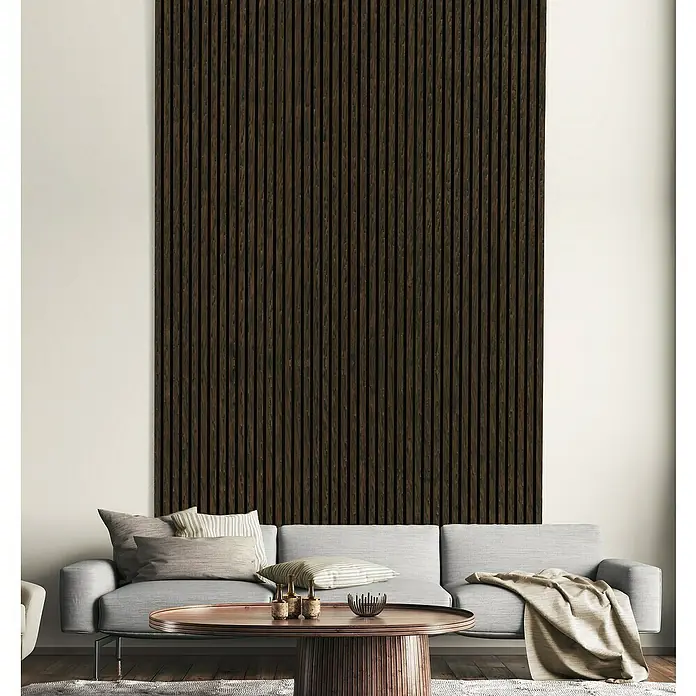 FN Neuhofer Akustikpaneel Acustico - Eiche geräuchert, L x B x S: 1.195 x 572,5 x 19 mm - Elegantes Wohnzimmer mit einer stilvollen, dunklen Holzpaneelwand, die einen modernen Kontrast zur grauen Couch und dem Holztisch bildet.