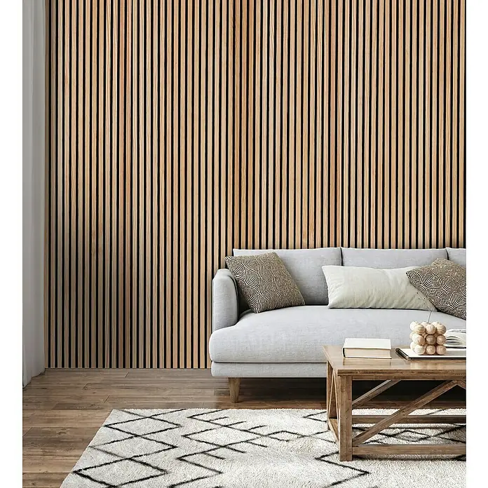 FN Neuhofer Akustikpaneel Acustico - Kiefer, L x B x S: 2.670 x 572,5 x 18 mm - Wohnzimmer-Interieur mit Akustikpaneelen an der Wand, einem grauen Sofa, einem Holztisch und einem gemusterten Teppich für ein modernes Ambiente.