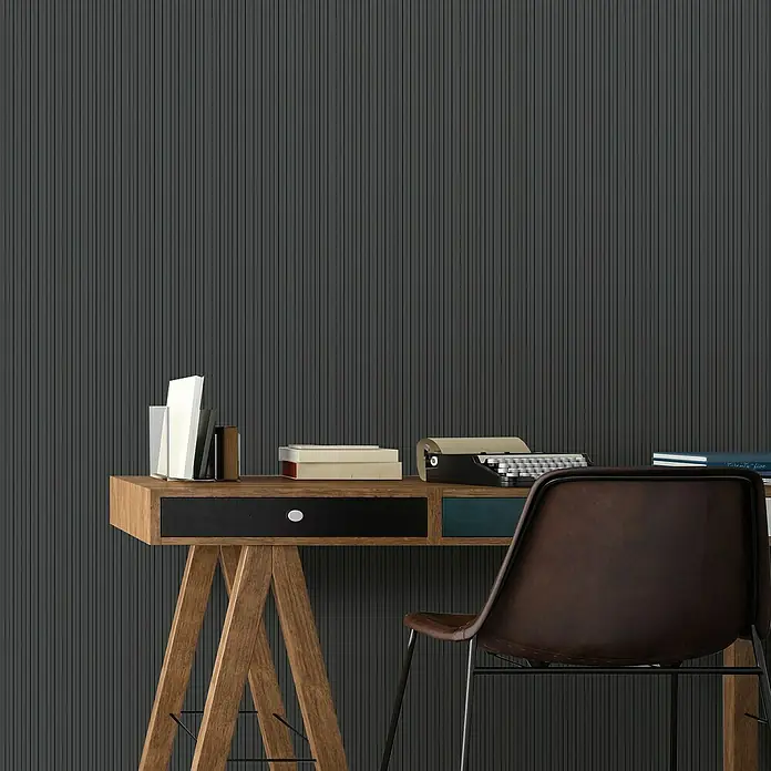 FN Neuhofer Wandpaneel Wally WA010 - Eiche schwarz, 2.670 x 118 x 12 mm - Büroumgebung mit Holztisch, Stuhl, Büchern und einer Schreibmaschine vor einer Wand mit vertikalen Streifen.