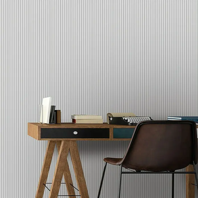 FN Neuhofer Wandpaneel Wally WA060 - Weiß, 2.670 x 118 x 12 mm - Nahaufnahme eines Holzschreibtischs mit Schreibmaschine, Büchern und einem Lederstuhl vor einer gestreiften Wand.