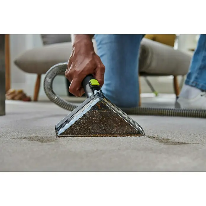 Ryobi ONE+ Akku-Waschsauger Pro RDC18BL-0 - 18 V, Ohne Akku, Behältervolumen: 1 l - Nahaufnahme eines Staubsaugers, der einen hellen Teppich reinigt, wobei der Fokus auf dem Schmutz und den Reinigungsergebnissen liegt.