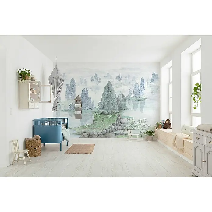 Komar Fototapete Fairyland - B x H: 350 x 250 cm, Vlies - Kinderzimmer mit blauem Kinderbett, bemalter Wand mit Landschaftsmotiv, hellem Holzboden und Fensterbank mit Kissen und Dekoration.