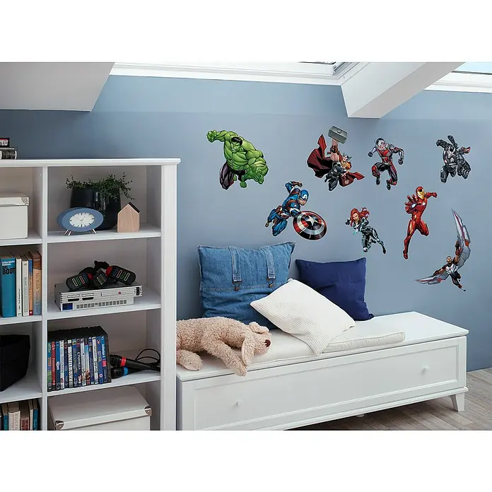 Komar Marvel Dekosticker Avengers Crew - 70 x 50 cm - Dieses Bild zeigt eine Sammlung von bunten Avengers Wandaufklebern, die ein Kinderzimmer auf einer blauen Wand schmücken. Sie verleihen dem Raum eine fantasievolle Note.