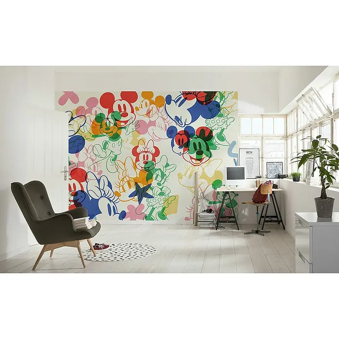 Komar Fototapete Disney Mickey & Minnie Mixture - B x H: 400 x 250 cm, Vlies - Zimmer mit einem bunten Mickey Mouse Wandbild, einem grauen Sessel, einem Schreibtisch und einem Fenster. Helle und verspielte Dekoration.