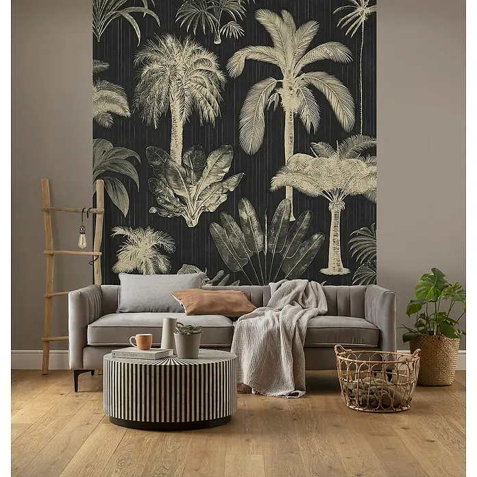 Komar Pure 2 Fototapete En Détail - B x H: 200 x 250 cm, Vlies - Wohnzimmer mit grauer Couch, gestreiftem Couchtisch und tropischer Tapete. Der Raum strahlt mit natürlichen Elementen Gemütlichkeit aus.
