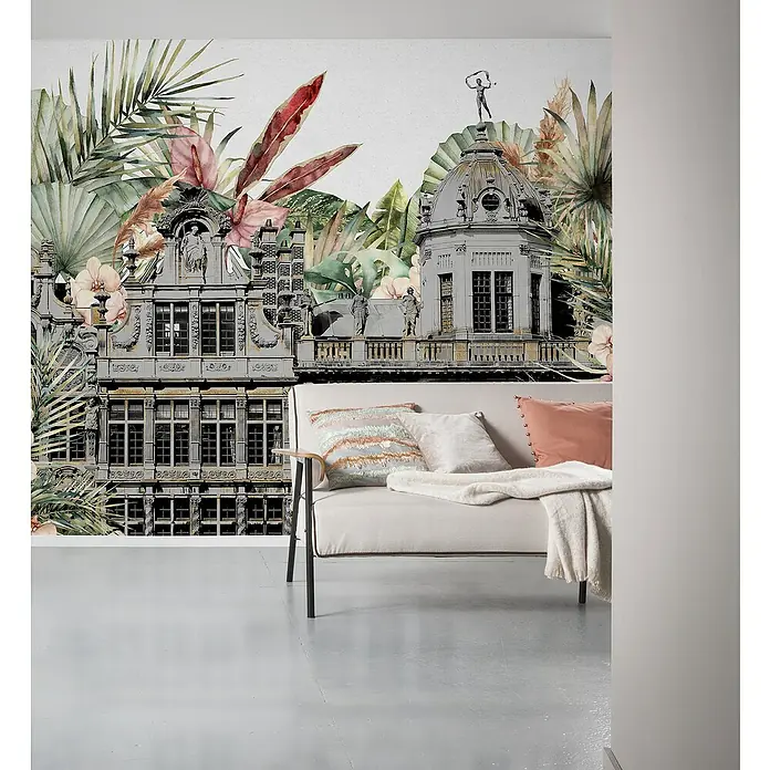 Komar Pure 2 Fototapete Tropical Palace - B x H: 300 x 250 cm, Vlies - Wandbild mit antikem Gebäude und tropischen Pflanzen hinter einem cremefarbenen Sofa mit Kissen und Decke.