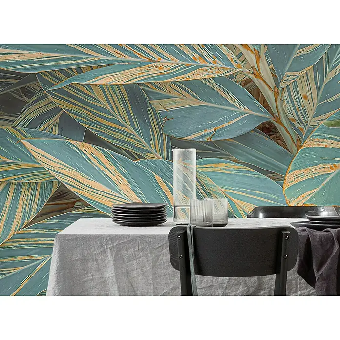 Komar Pure 2 Fototapete Amazonia Vibes - B x H: 400 x 250 cm, Vlies - Gedeckter Tisch mit Geschirr und Gläsern vor einem Hintergrund aus großen, blau-gelben Blättern für eine elegante Tischdekoration.