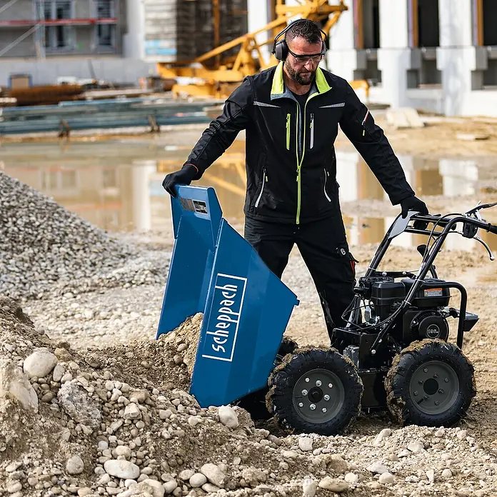 Scheppach Raddumper DP 3000 - 4.100 W, 196 cm³, Fassungsvermögen: 125 l, Benzin - Der Scheppach Mini-Dumper mit robustem Motor und blauer Kippmulde im Einsatz auf der Baustelle. Praktisch für den Materialtransport.