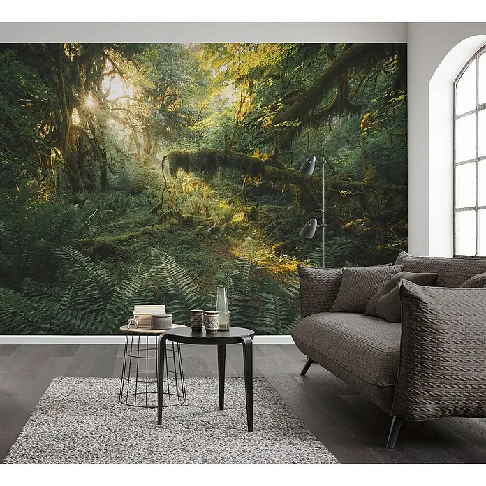 Komar Pure 2 Fototapete Hall of Mosses - B x H: 400 x 250 cm, Vlies - Wohnzimmer mit auffälliger Waldtapete, grauem Sofa, Teppich und dunklem Holzboden für eine gemütliche Atmosphäre.