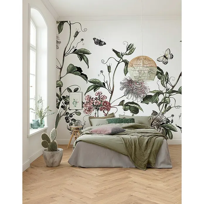 Komar Pure 2 Fototapete Paradis de Papillons - B x H: 400 x 250 cm, Vlies - Schlafzimmer mit botanischer Wandtapete, großem Bett mit grüner Bettwäsche und Rattanlampe.