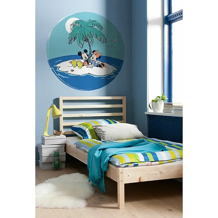 Komar Dots Fototapete rund Disney Mickey and Minnie Remote Island - 128 cm, Selbstklebend - Kinderzimmer mit einem Holzbett, blau gestrichenen Wänden und einem Wandbild von Mickey und Minnie Maus auf einer tropischen Insel.