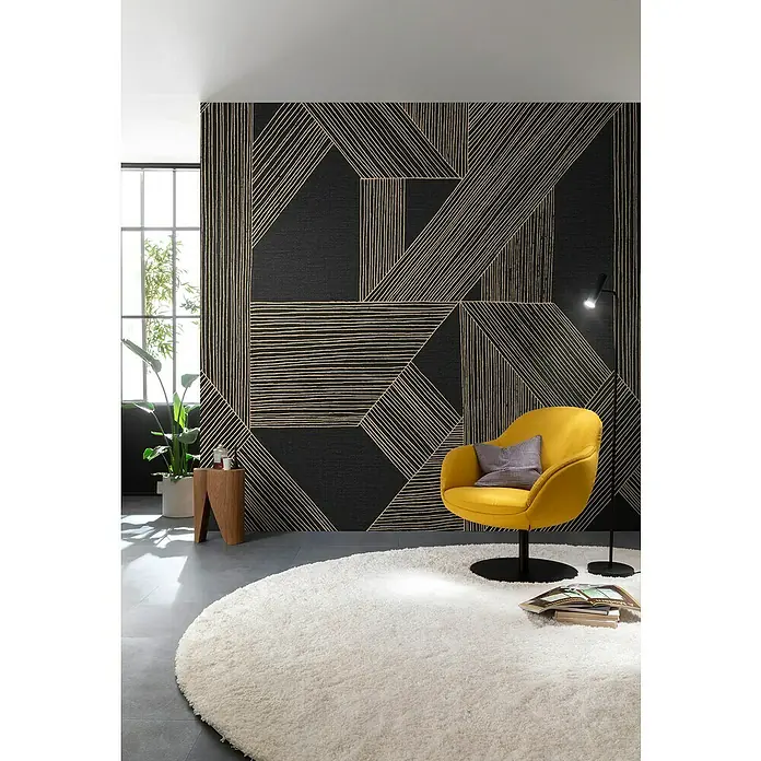 SCHÖNER WOHNEN-Kollektion Cosyliving Fototapete Linien - B x H: 265 x 300 cm, Vlies, Schwarz-Gold - Ein schickes Wohnzimmer mit einem gelben Sessel und einem runden, weißen Teppich vor einer Wand mit geometrischem Muster.