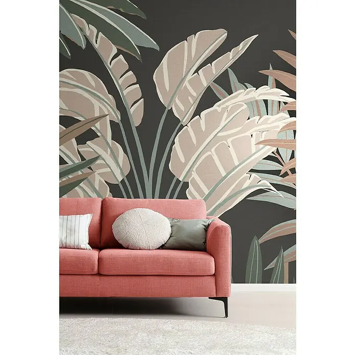 SCHÖNER WOHNEN-Kollektion Cosyliving Fototapete Dschungel - B x H: 318 x 300 cm, Vlies, Schwarz-Mehrfarbig - Korallenfarbenes Sofa mit tropischem Blattmuster im Hintergrund, dazu ein weißer Teppich für einen Hauch von Komfort und Stil.