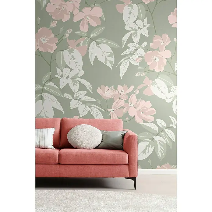 SCHÖNER WOHNEN-Kollektion Cosyliving Fototapete Blumen - B x H: 265 x 300 cm, Vlies, Taupe-Rosa - Nahaufnahme eines korallenroten Sofas mit Zierkissen vor einer floralen Tapete, das ein gemütliches und stilvolles Ambiente vermittelt.