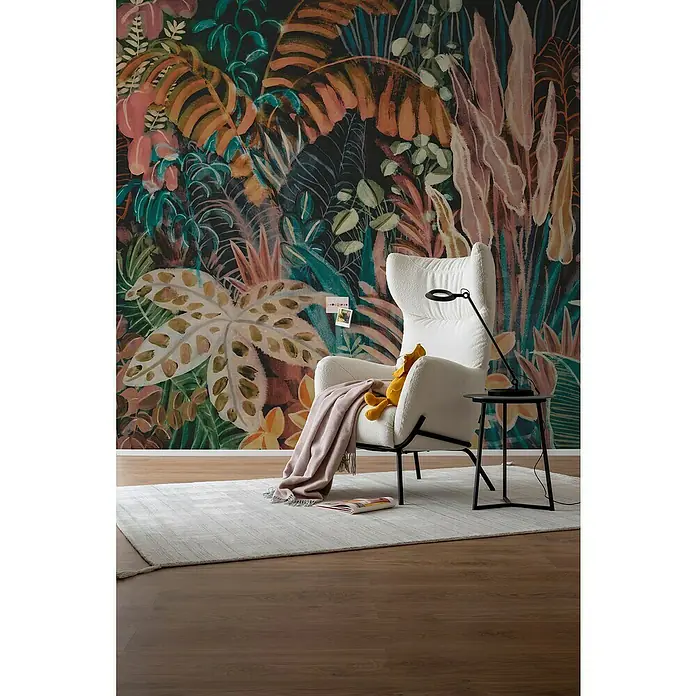 SCHÖNER WOHNEN-Kollektion Cosyliving Fototapete Blätterwald - B x H: 318 x 300 cm, Vlies, Rosa-Mehrfarbig - Gemütliche Leseecke mit einem weißen Sessel, einer Stehlampe und einem kleinen Beistelltisch vor einer Wand mit tropischem Pflanzenmuster.