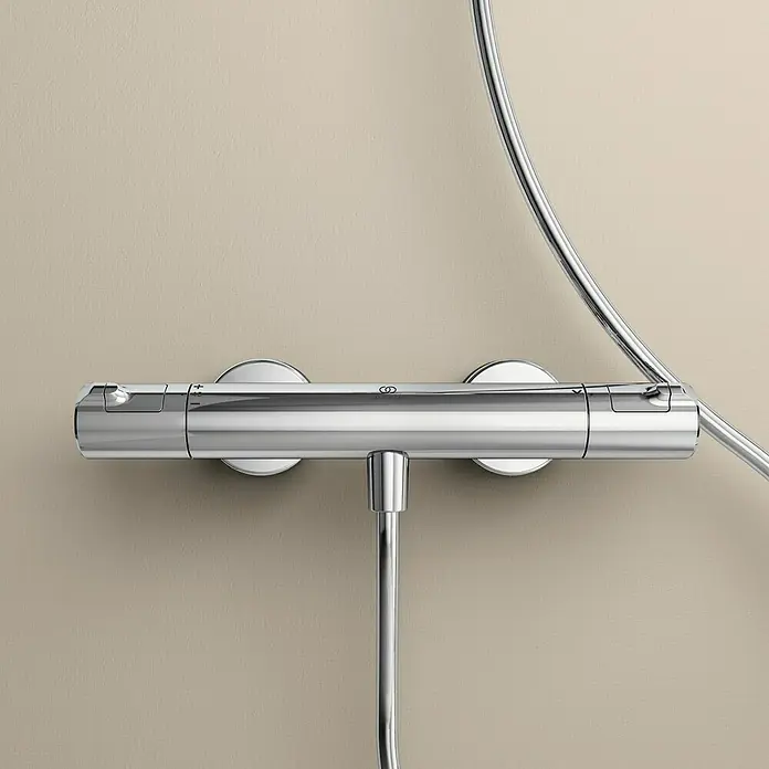 Ideal Standard Ceratherm Brausethermostat T50 - Chrom - Eine Nahaufnahme einer glänzenden, verchromten Duscharmatur, die an einer hellen Wand montiert ist und ein modernes Design aufweist.