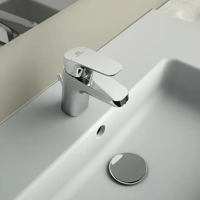 Ideal Standard Ceraflex Waschtischarmatur - Höhe: 13,3 cm, Chrom, Glänzend - Nahaufnahme einer glänzenden, modernen Waschtischarmatur aus Chrom auf einem weißen Waschbecken mit einem Abflussstopfen.