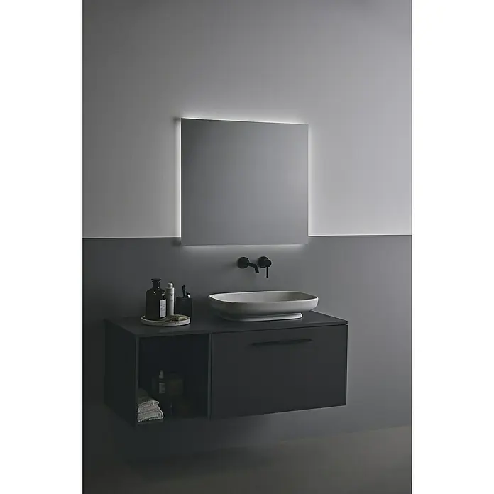 Ideal Standard Ceraline Waschtischarmatur - Schwarz, Matt - Ein stilvolles Badezimmer-Ensemble mit einem modernen Waschtischunterschrank und einem beleuchteten Spiegel, das Eleganz und Funktionalität vereint.