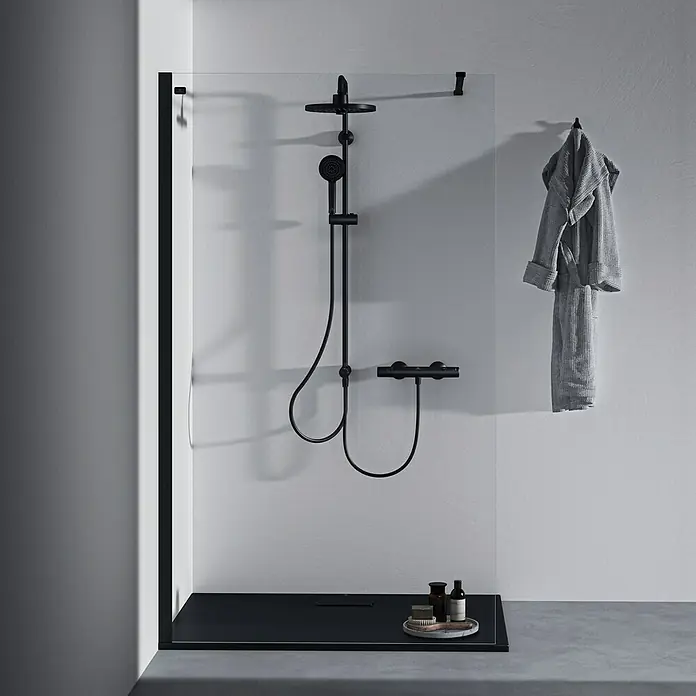 Ideal Standard Ceratherm Brausethermostat T25 - Schwarz - Elegantes Badezimmer mit einer modernen Duschkabine in Schwarz und klarem Glas. Der minimalistische Stil wird durch eine schwarze Duscharmatur betont.