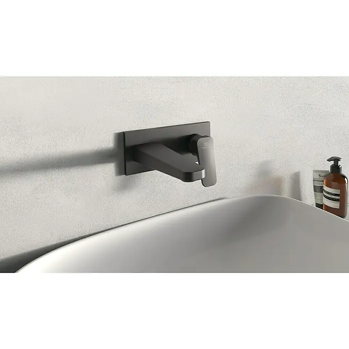 Ideal Standard Ceraplan WaschtischarmaturSchwarz, Matt - Eine moderne, matte, schwarze Waschtischarmatur mit Hebel, die an einer strukturierten Wand montiert ist und Eleganz ausstrahlt.