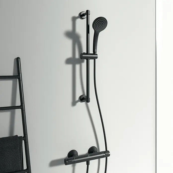 Ideal Standard Ceratherm Brausethermostat T25 - Schwarz - Schwarze Duscharmatur mit Handbrause und Thermostat an einer weißen Wand im Badezimmer.