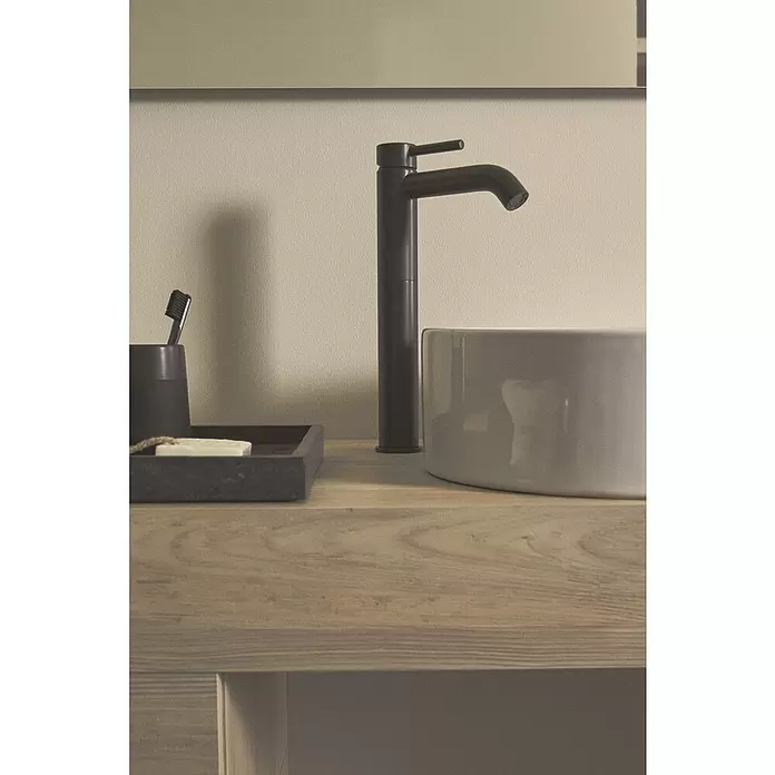 Ideal Standard Ceraline Grifo de lavabo - Altura: 32,1 cm, Negro, Mate, Sin juego de desagüe - Grifo negro moderno y lavabo de cerámica gris sobre tocador de madera clara, con accesorios de baño.