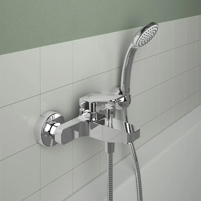 Ideal Standard Ceraplan Badewannenarmatur - Ausladung Armatur: 163 mm, Chrom, Glänzend - Nahaufnahme einer glänzenden Chrom-Badewannenarmatur mit Handbrause an einer gefliesten Wand.