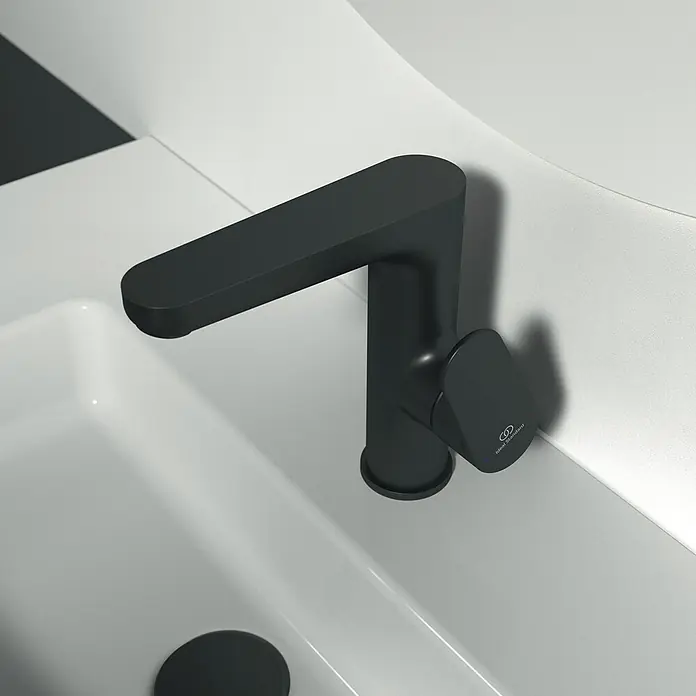 Ideal Standard Cerafine O Waschtischarmatur H155 - Schwarz, Matt, Mit Ablaufgarnitur - Naheaufnahme eines eleganten, mattschwarzen Waschbeckenhahns, der modernes Baddesign verkörpert und eine minimalistische Ästhetik bietet.