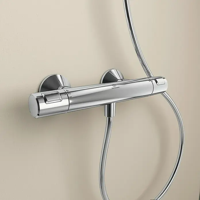 Ideal Standard Ceratherm Brausethermostat T25 - Chrom - Nahaufnahme einer glänzenden, verchromten Ideal Standard Duscharmatur an einer Wand befestigt, die moderne Eleganz ausstrahlt.