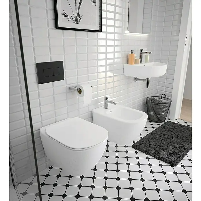 Ideal Standard Cerafine O Waschtischarmatur H120 - Chrom, Glänzend, Mit Ablaufgarnitur - Das Badezimmer präsentiert eine moderne Toilette mit Bidet, Waschbecken und einem stilvollen schwarz-weißen Fliesenmuster.