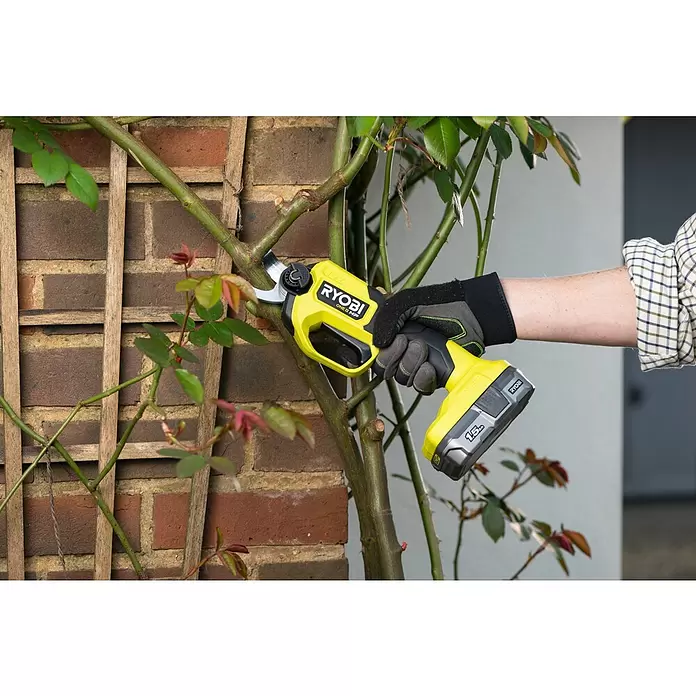 Ryobi ONE+HP Akku-Gartenschere RY18SCXA-120T - 18 V, Li-Ionen, 1 Akku, Max. Aststärke: 28 mm - Behändigte Hand schneidet mit einer gelb-schwarzen Ryobi Akku-Astschere einen Rosentrieb.